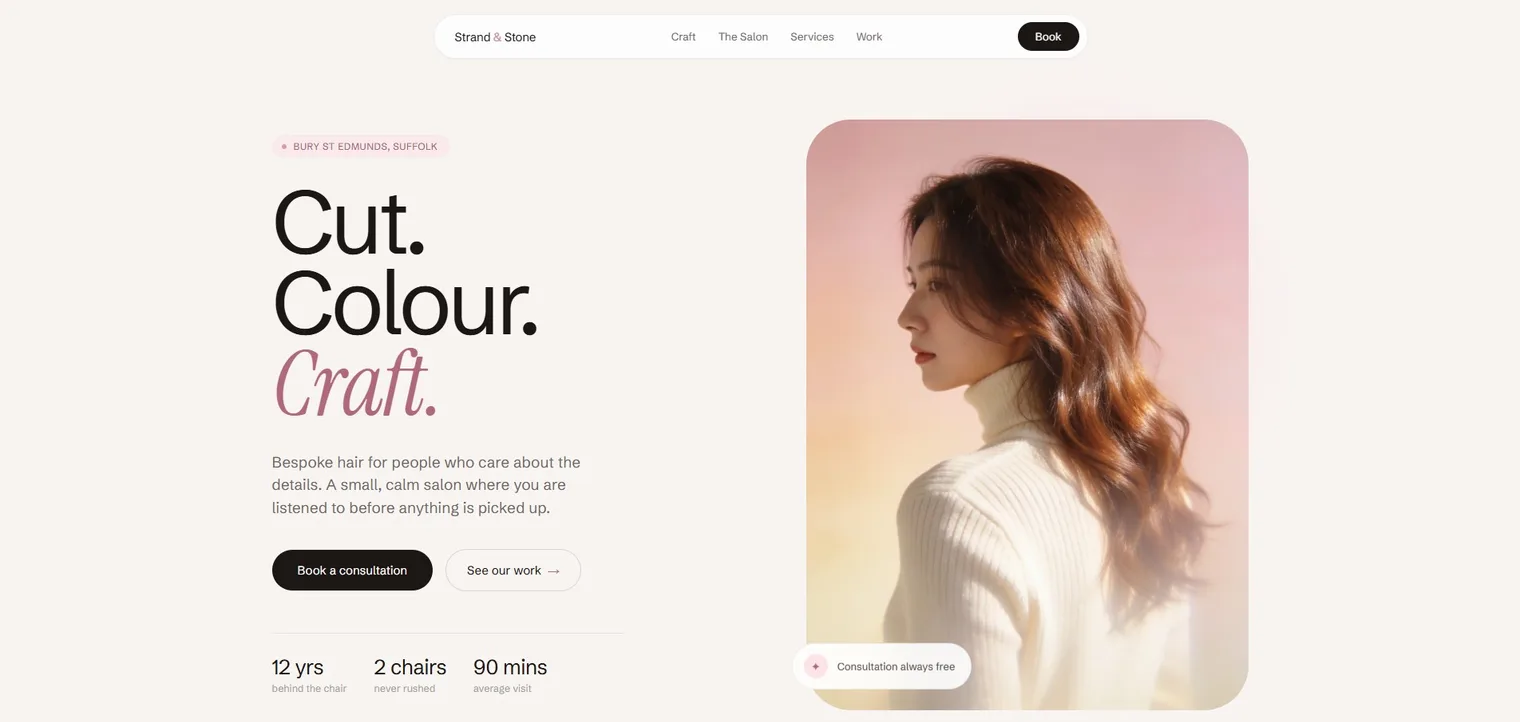 The Strand & Stone hair salon homepage, a portrait of long auburn hair in warm pink light beside a Cut, Colour, Craft headline and a Book a consultation button